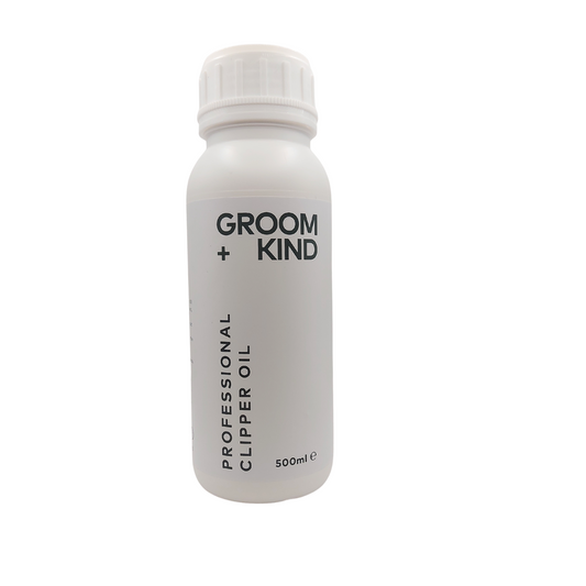 White bottle of Groom + Kind professional clipper oil on a white background