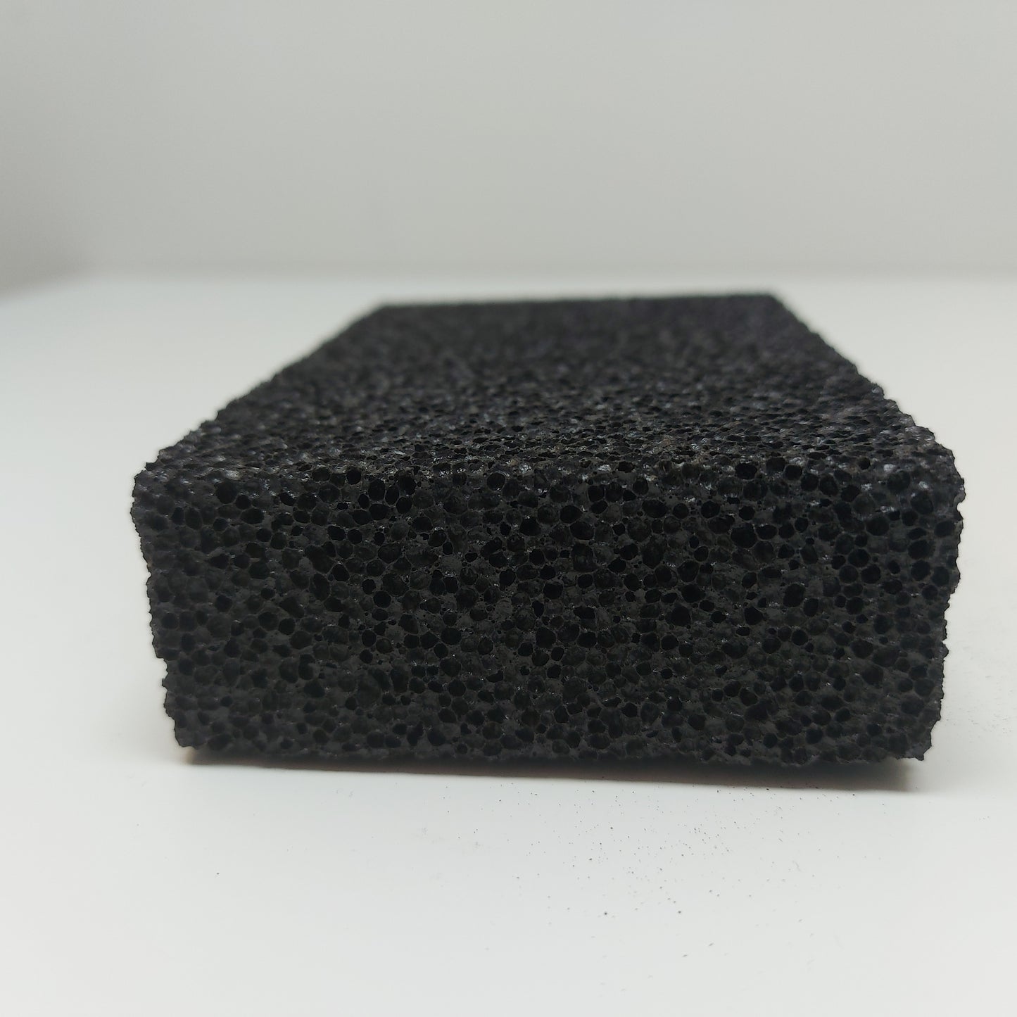 Close-up of the textured surface of a stripping stone, showing porous material for grip
