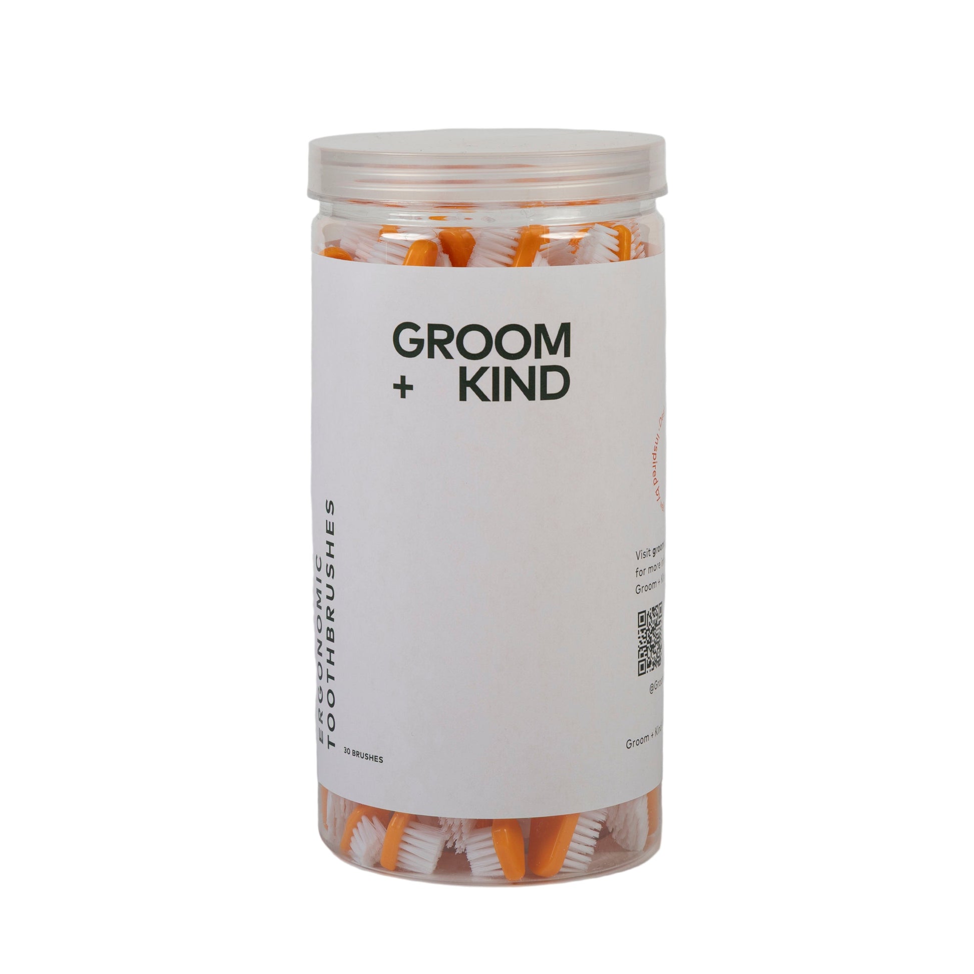 Jar of professional toothbrushes labeled 'Groom + Kind' on a white background