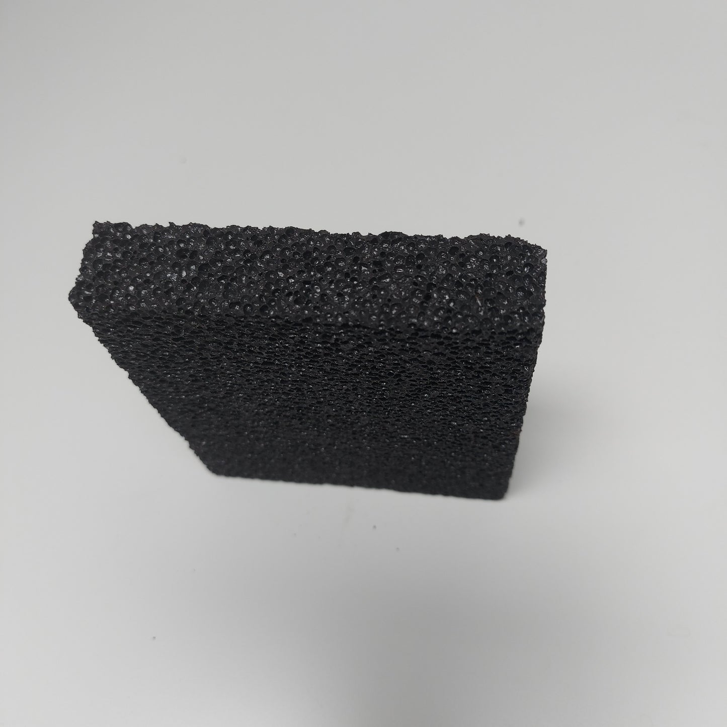 Close-up of small stripping stone texture, highlighting its porous surface for effective hand-stripping.