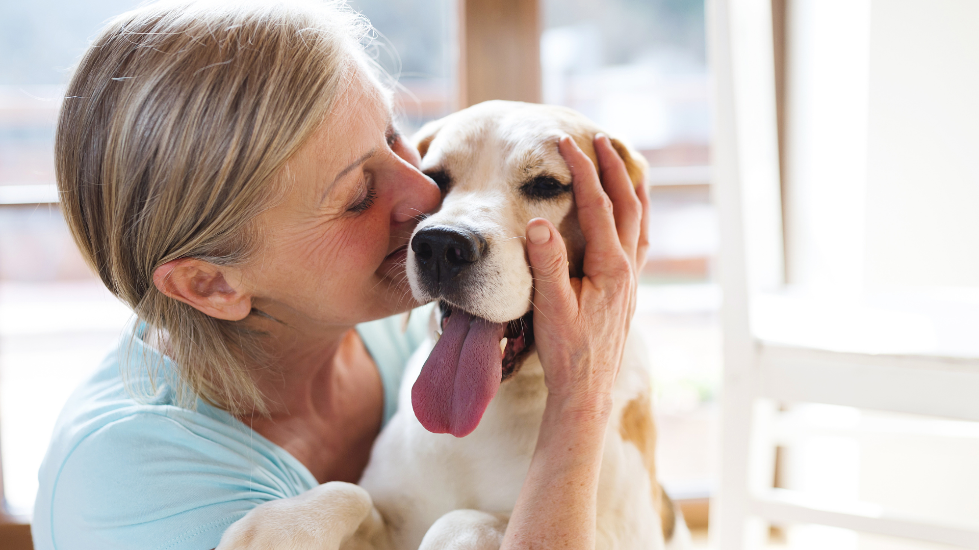 Woman cuddling and smelling her dog