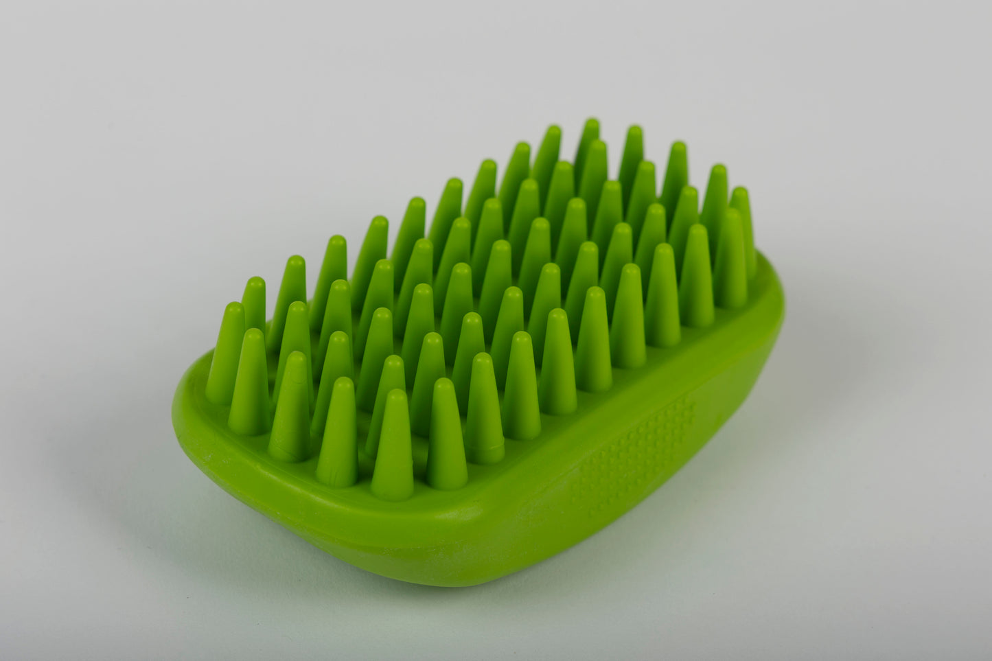 Close up of grooming brush with textured surface on a white background