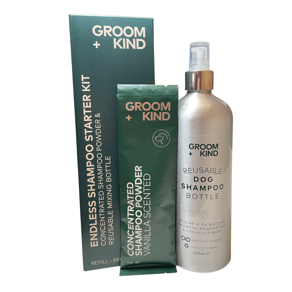 Groom + Kind reusable dog shampoo bottle and refill kit in green and silver packaging, shown on a plain white background.