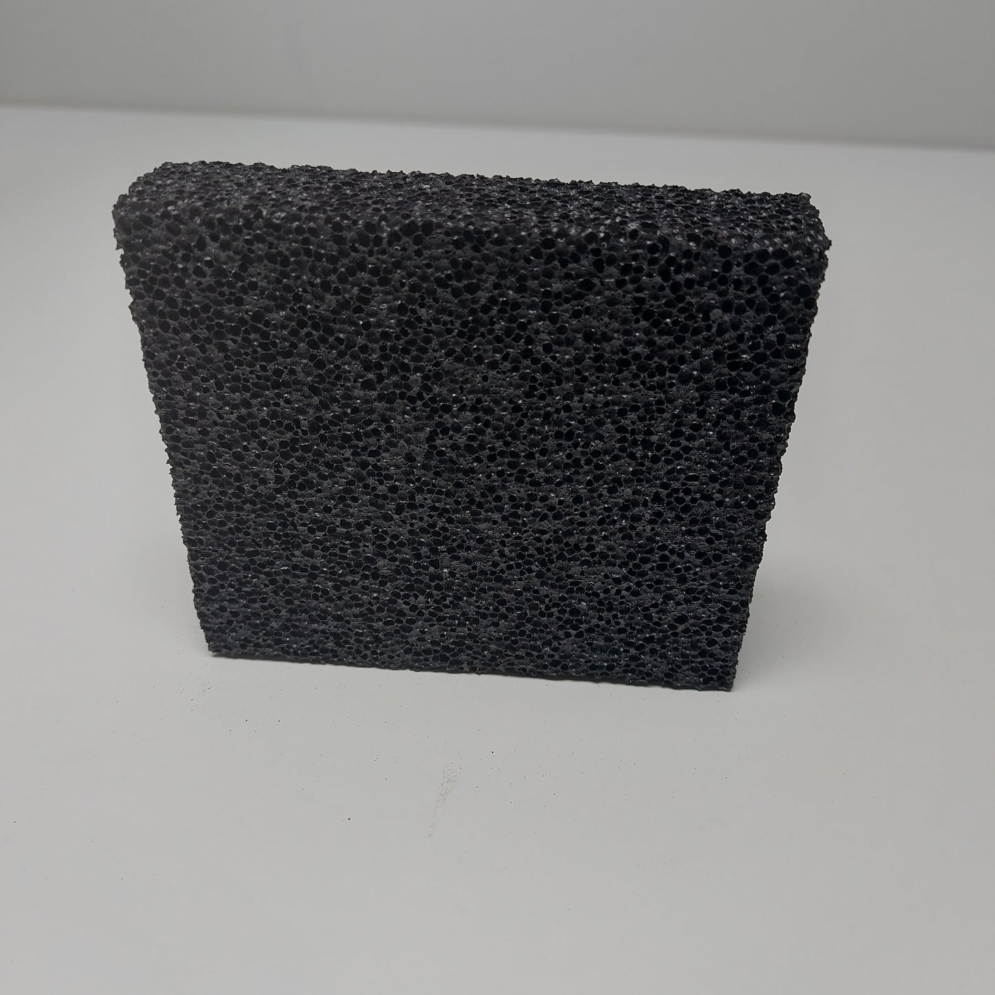Close-up of textured surface of a small grooming stripping stone, designed for removing undercoat hair.