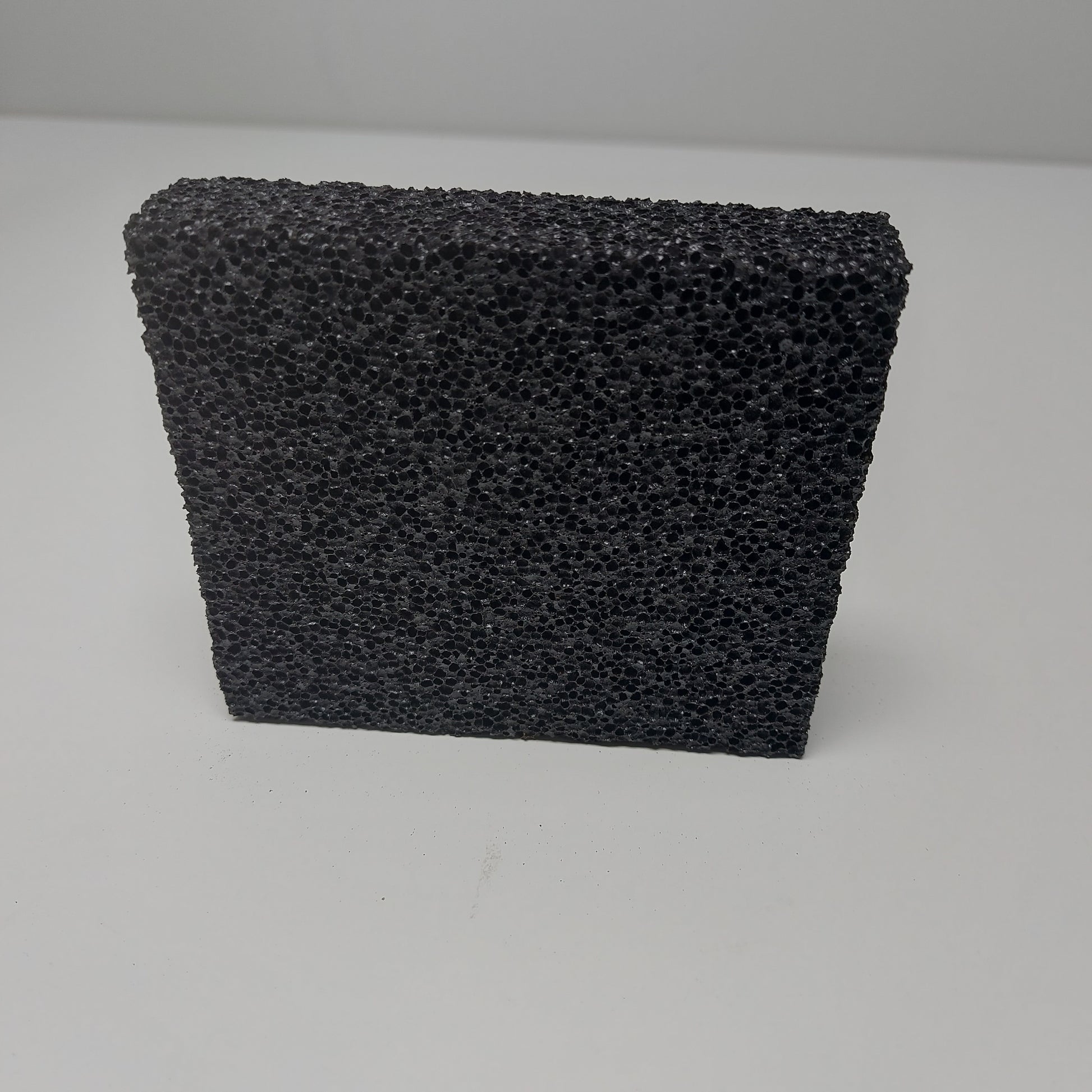 Close-up of textured surface of a small grooming stripping stone, designed for removing undercoat hair.